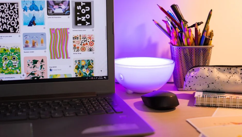 A close-up of a modern workspace, featuring a laptop and smartphone in use.