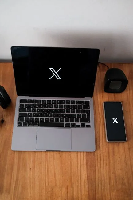 Top view of a minimalist setup featuring a tablet and smartphones on a white surface.