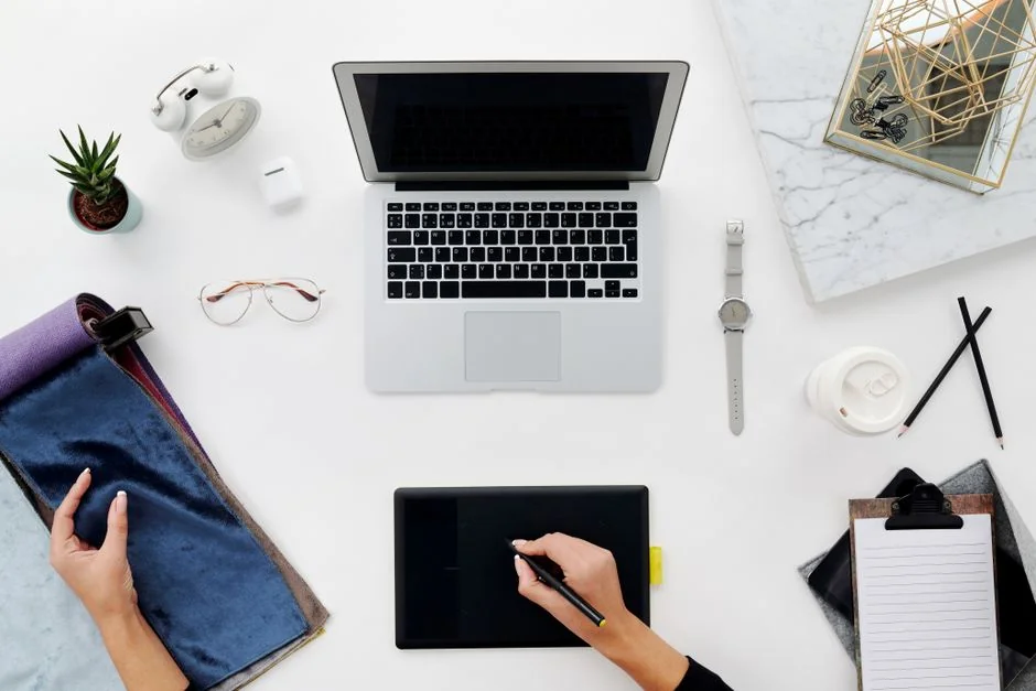 Top view of a sleek modern office desk with a laptop, tablet, and accessories.